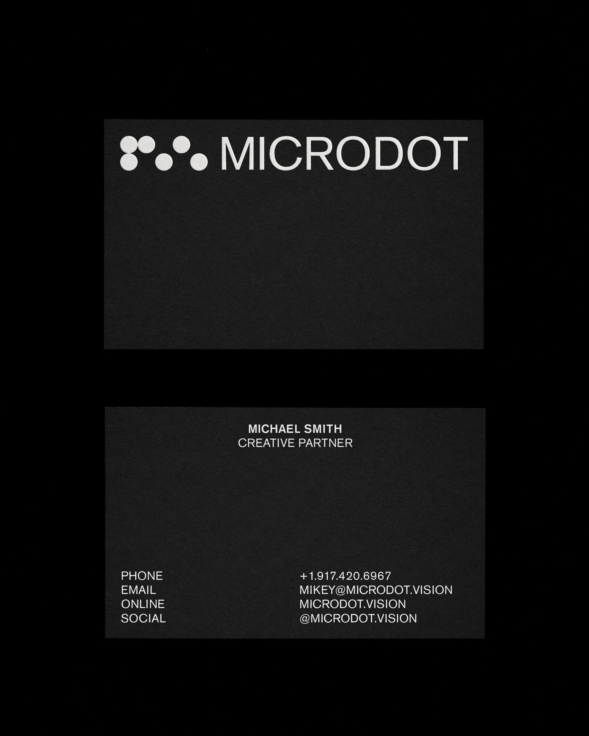 Professional business card for Microdot, featuring company logo, contact information, and Michael Smith's title as Creative Partner.