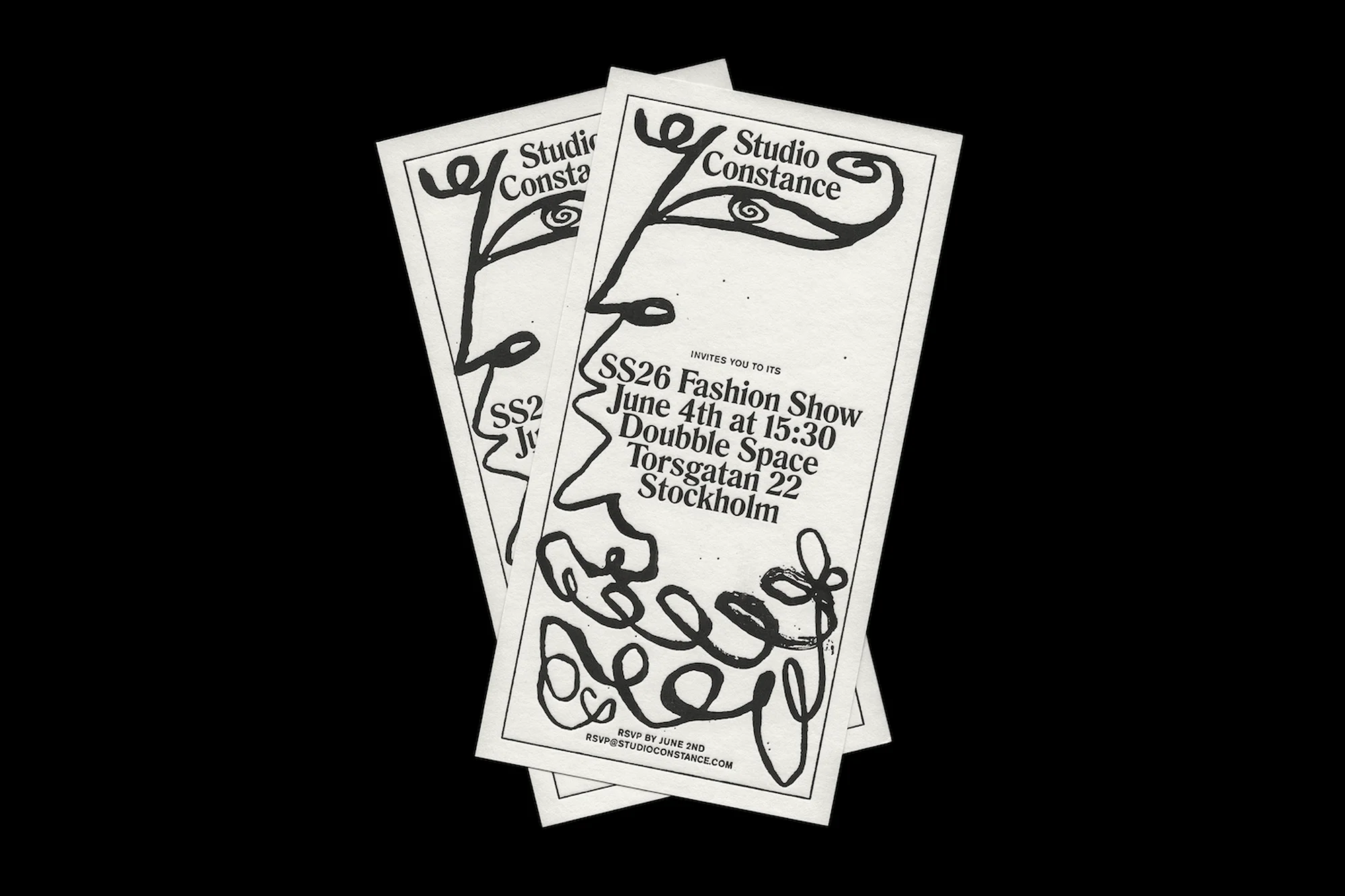 Three white invitations stacked, featuring a black graphic face and event details for a fashion show by Studio Constance.
