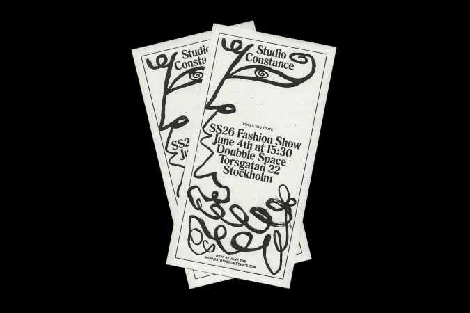 Three white invitations stacked, featuring a black graphic face and event details for a fashion show by Studio Constance.