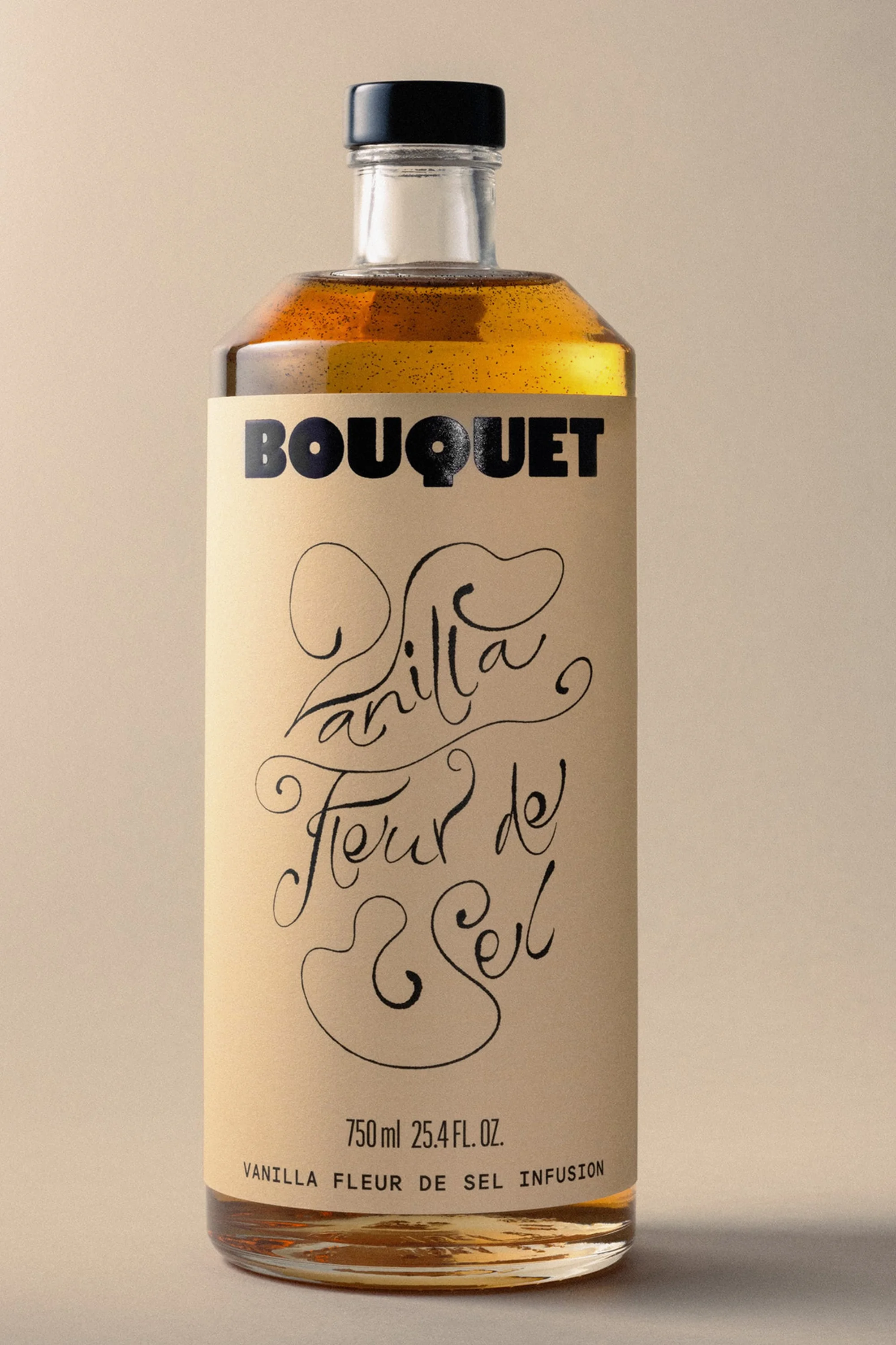 Glass bottle with vanilla fleur de sel infusion, featuring a beige label with black vintage style calligraphy script lettering.
