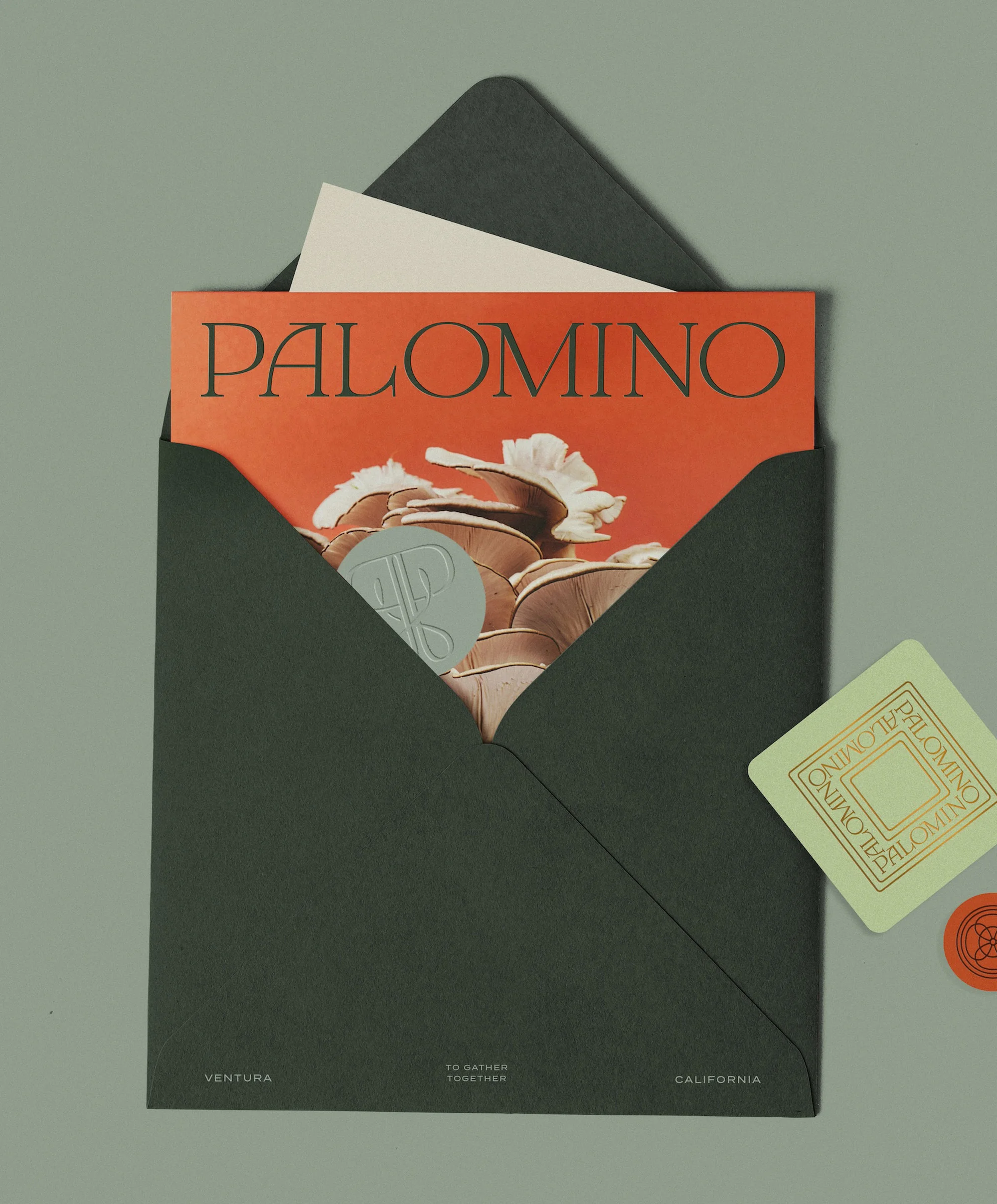 Palomino magazine inside a green envelope with a wax seal and a card on a light green background, evoking an invitation concept.