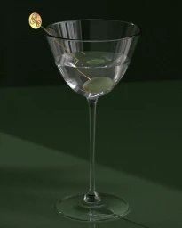 A martini glass containing a clear cocktail, a green olive, and a gold cocktail pick resting on a dark green surface
