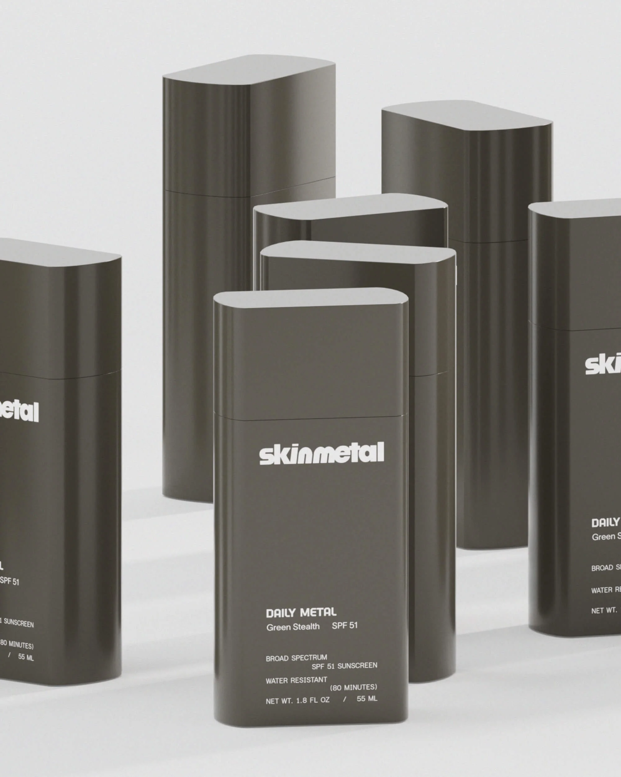 Group of Skinmetal Daily Metal Green Stealth SPF 51 sunscreen bottles. The sleek packaging features a modern design and minimalist aesthetic.