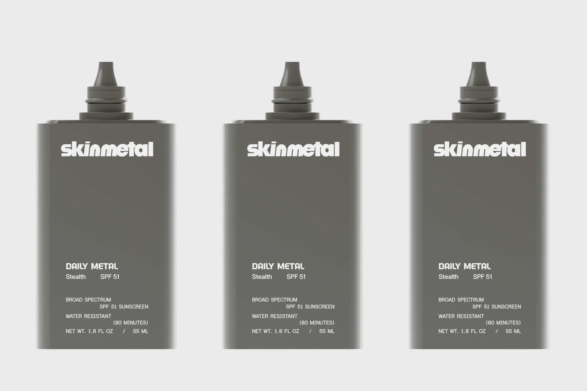 Three grey Skinmetal SPF 51 sunscreen bottles stand side-by-side against a plain white backdrop in a clean product shot.