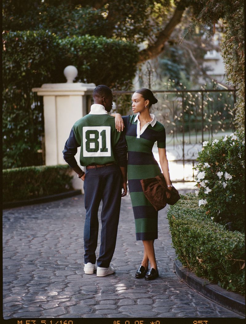 Two people in fashionable clothing on a cobblestone path, surrounded by lush greenery, showcasing a blend of casual and elegant styles.