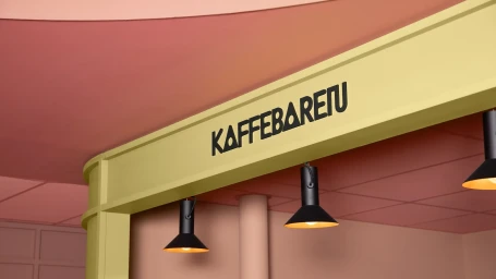Interior shot of Kaffebaren featuring black pendant lights mounted below a pale yellow beam against a warm terracotta ceiling.