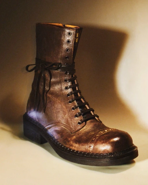 A single brown leather lace-up boot is presented against a neutral backdrop, highlighting its intricate details and rugged texture.