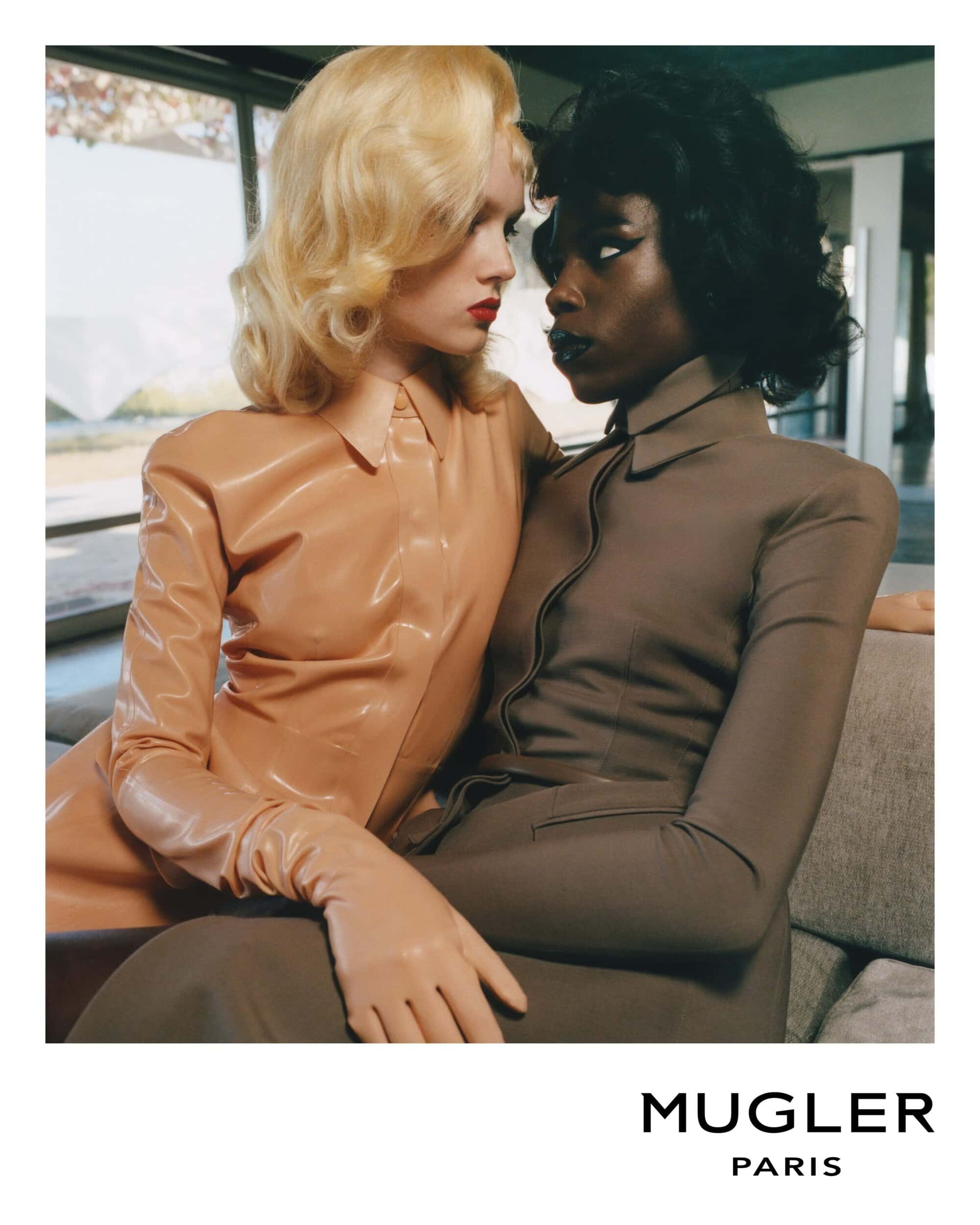 Two fashion models pose in a photo studio. One has blonde hair wearing beige, and the other has black hair wearing brown matching outfits.
