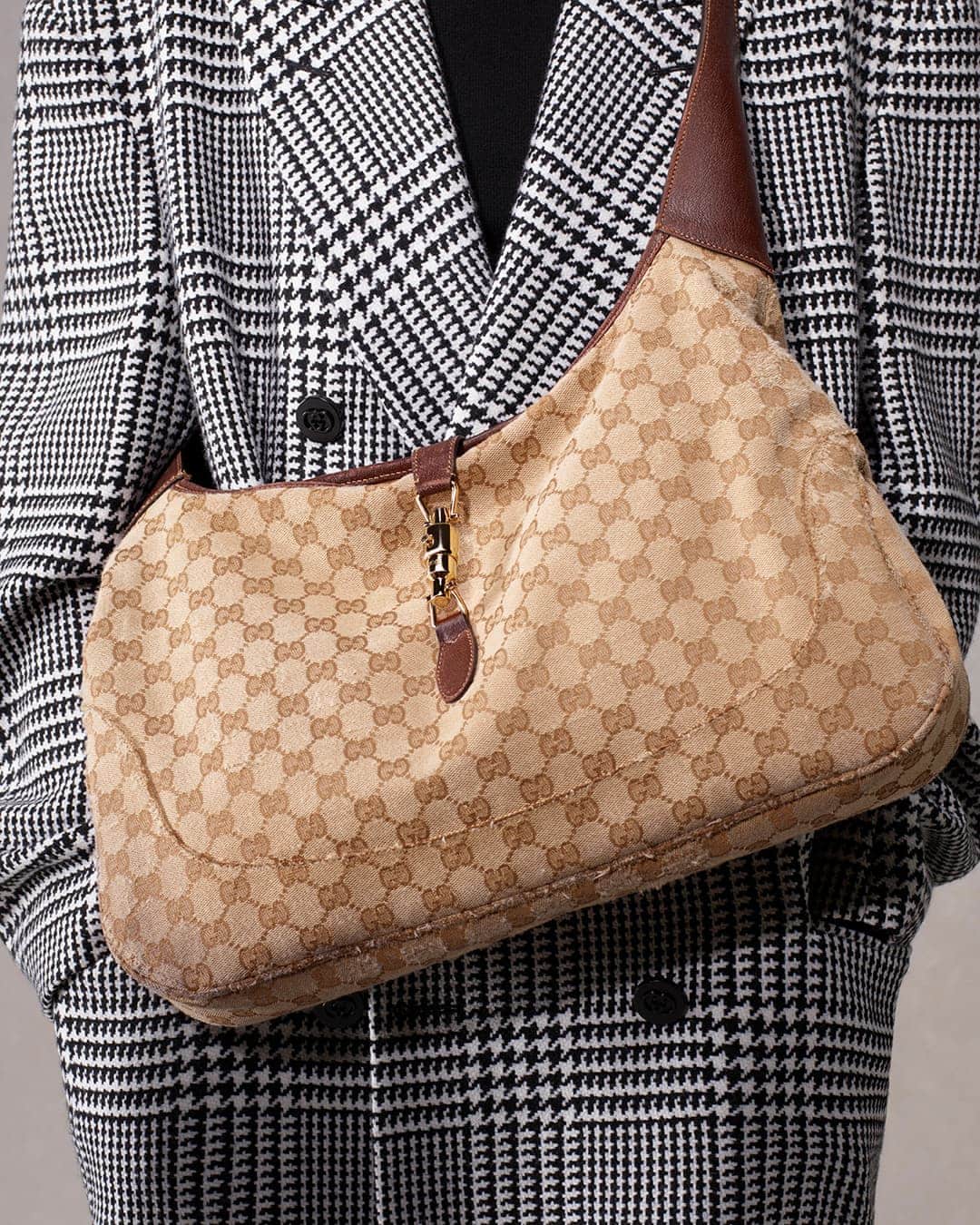 Gucci Jackie hobo bag in beige and brown canvas with a black and white houndstooth coat. Fashionable designer handbag.