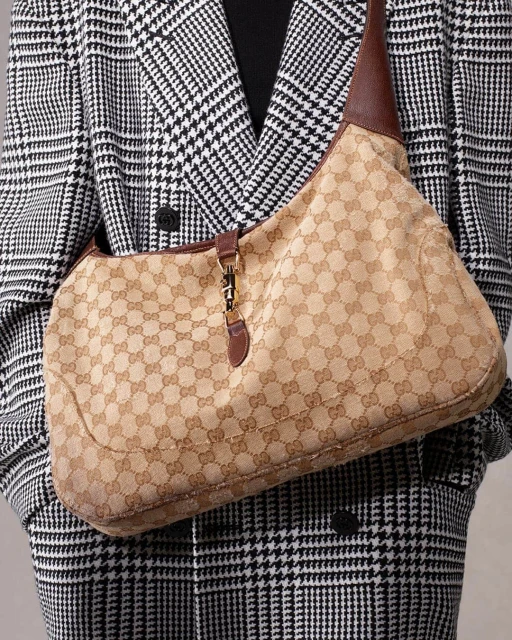 Gucci Jackie hobo bag in beige and brown canvas with a black and white houndstooth coat. Fashionable designer handbag.