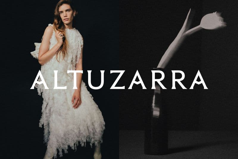 Fashion model in a white feathered dress, dark studio backdrop, soft lighting. Altuzarra brand logo. Minimalist aesthetic fashion image.