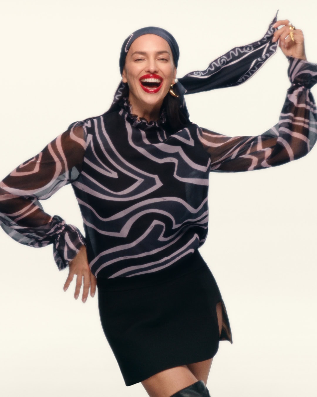 Model Irina Shayk wearing a patterned headscarf and printed blouse for Pucci Holiday 2025 ad campaign.