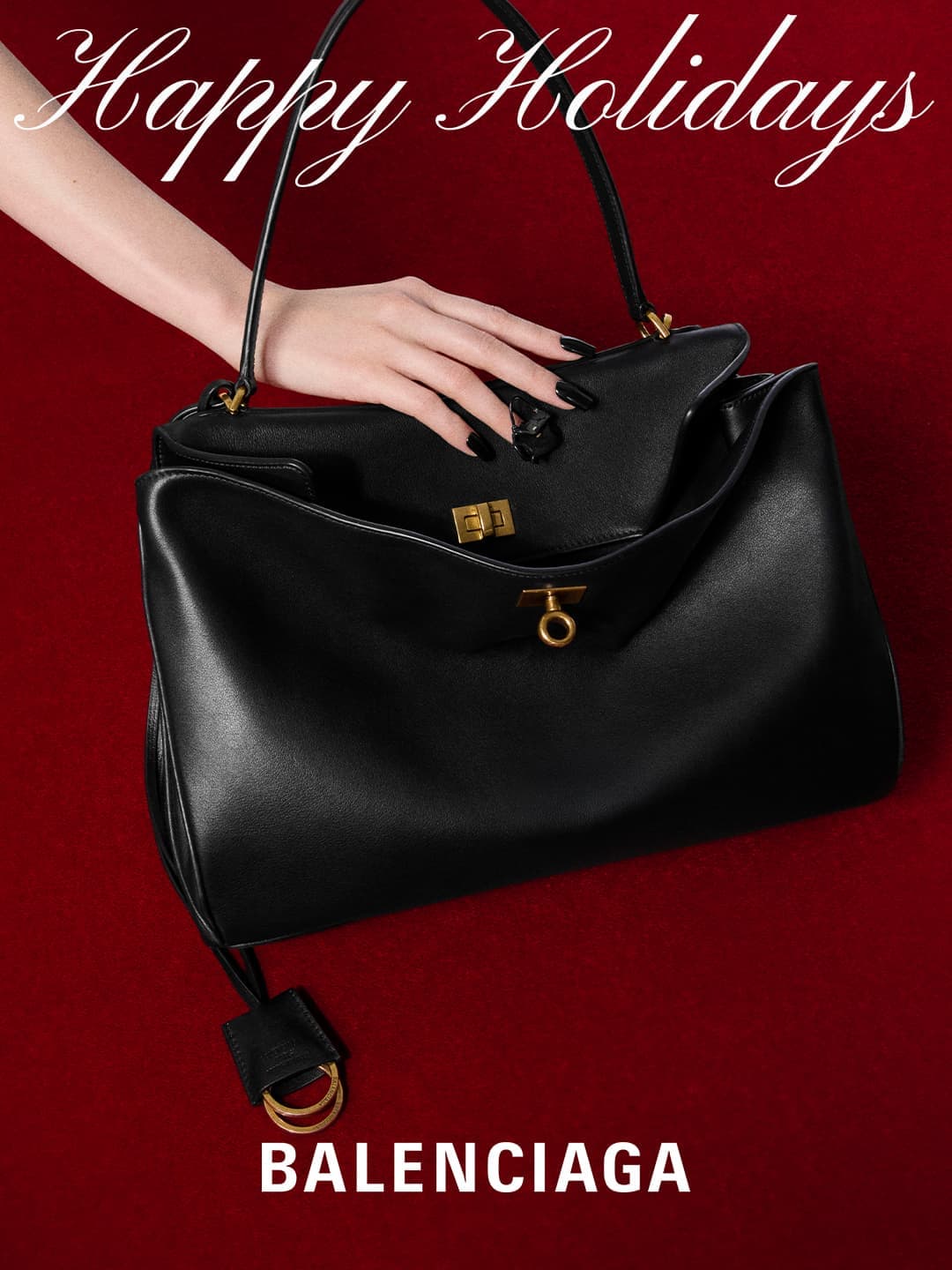 Black Balenciaga handbag displayed on a red background with a woman's hand opening the purse, and the text 'Happy Holidays'.