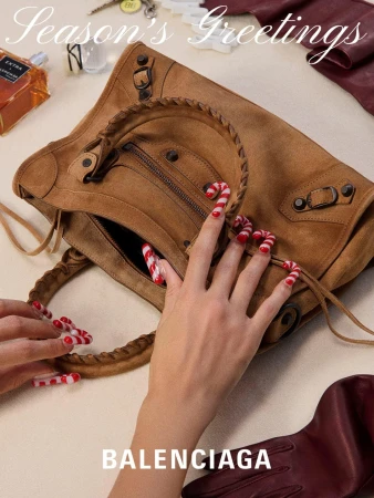Brown Balenciaga handbag with candy cane nail art against a neutral background. Holiday-themed fashion accessory still life.