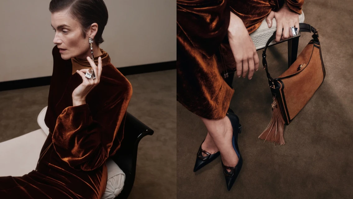 A sophisticated woman in a brown velvet dress poses with jewelry, seated next to a stylish brown leather handbag with tassel detail.