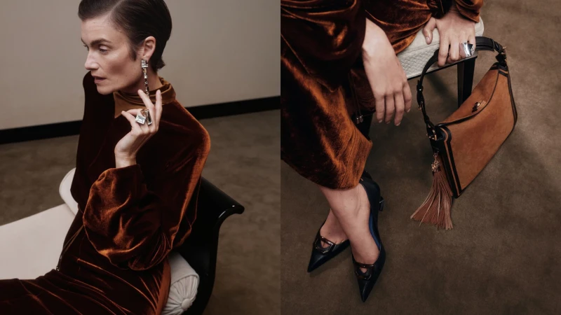 A sophisticated woman in a brown velvet dress poses with jewelry, seated next to a stylish brown leather handbag with tassel detail.
