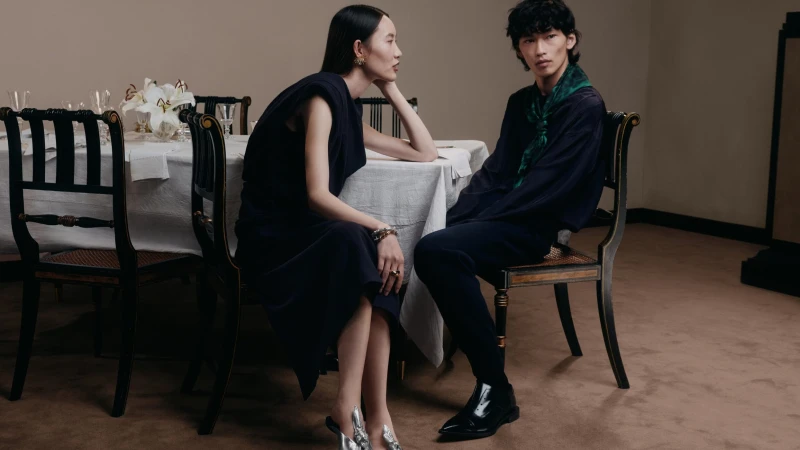 Two models seated at a dining table in an interior setting for Lanvin campaign photography by Chris Lensz.