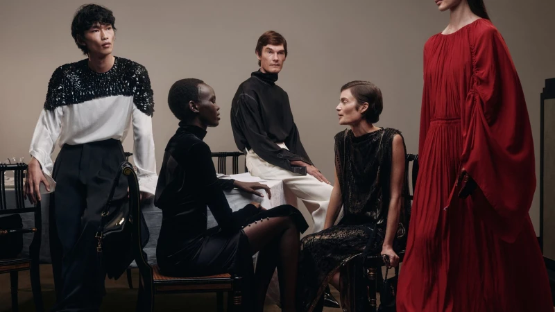 Group of models posing in sophisticated designer attire against a neutral studio background for Lanvin