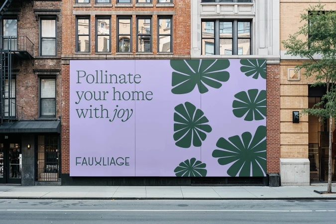 Urban billboard advertisement for Fauxliage featuring modern plant illustrations against a contemporary brick building backdrop.