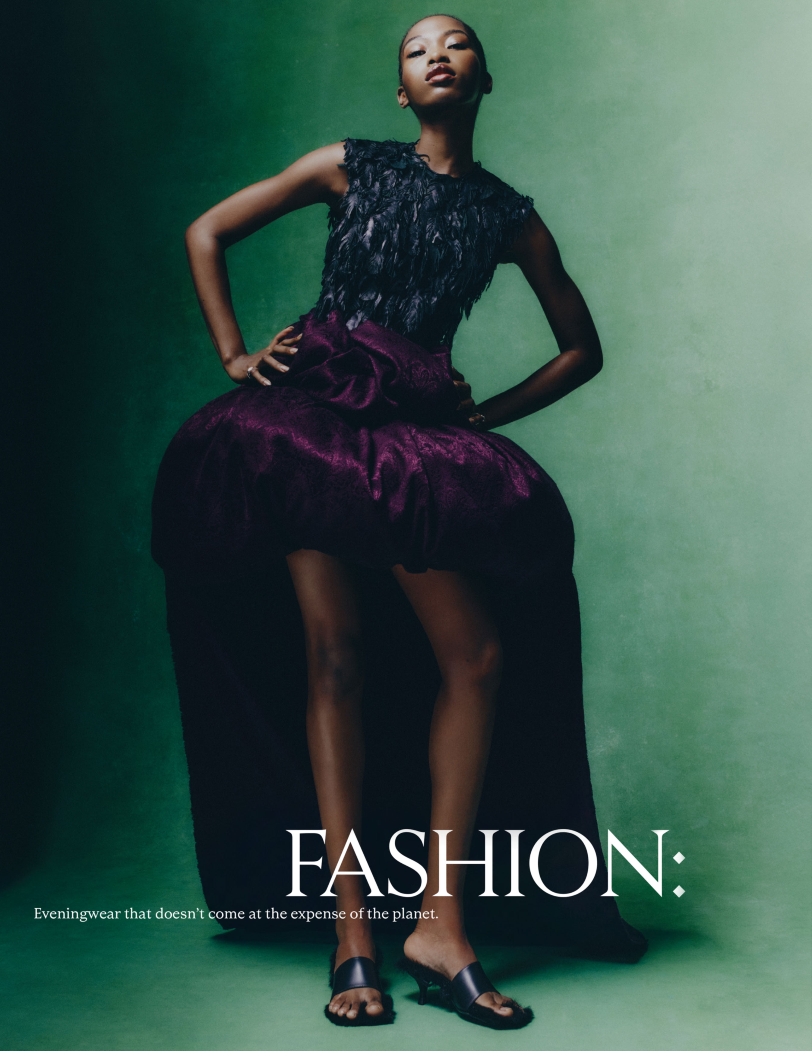 Fashion editorial portrait of a Black female model in a sculptural dress with a feathered bodice on a green background, studio shot.