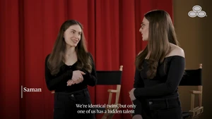 Two young women with long brown hair talking in front of red curtains and director chairs for State Farm Nolan Smith Hidden Talents campaign