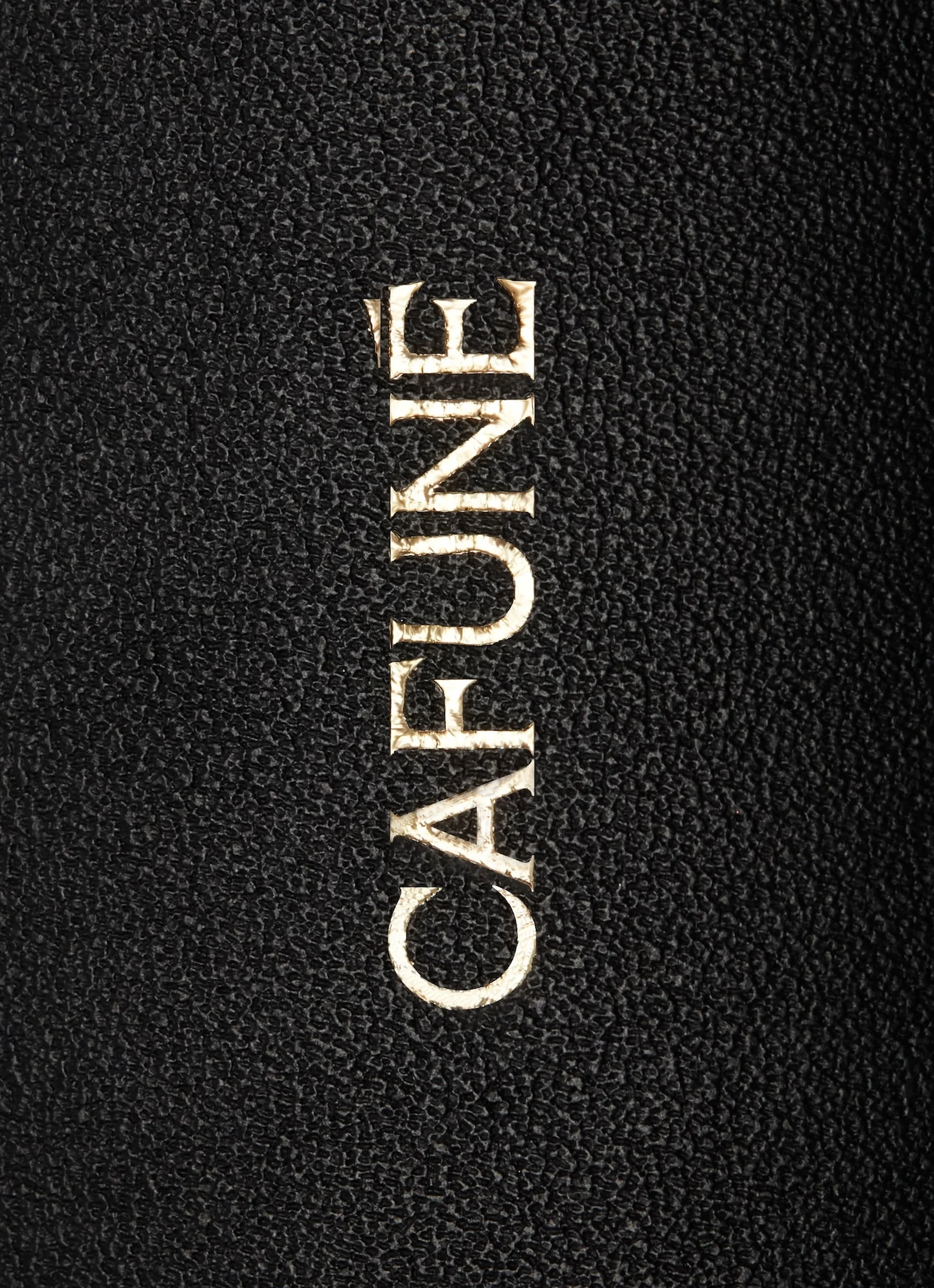 Close-up of the word 'CAFUNE' in gold lettering against a black, textured material, likely leather or a leather-like fabric.