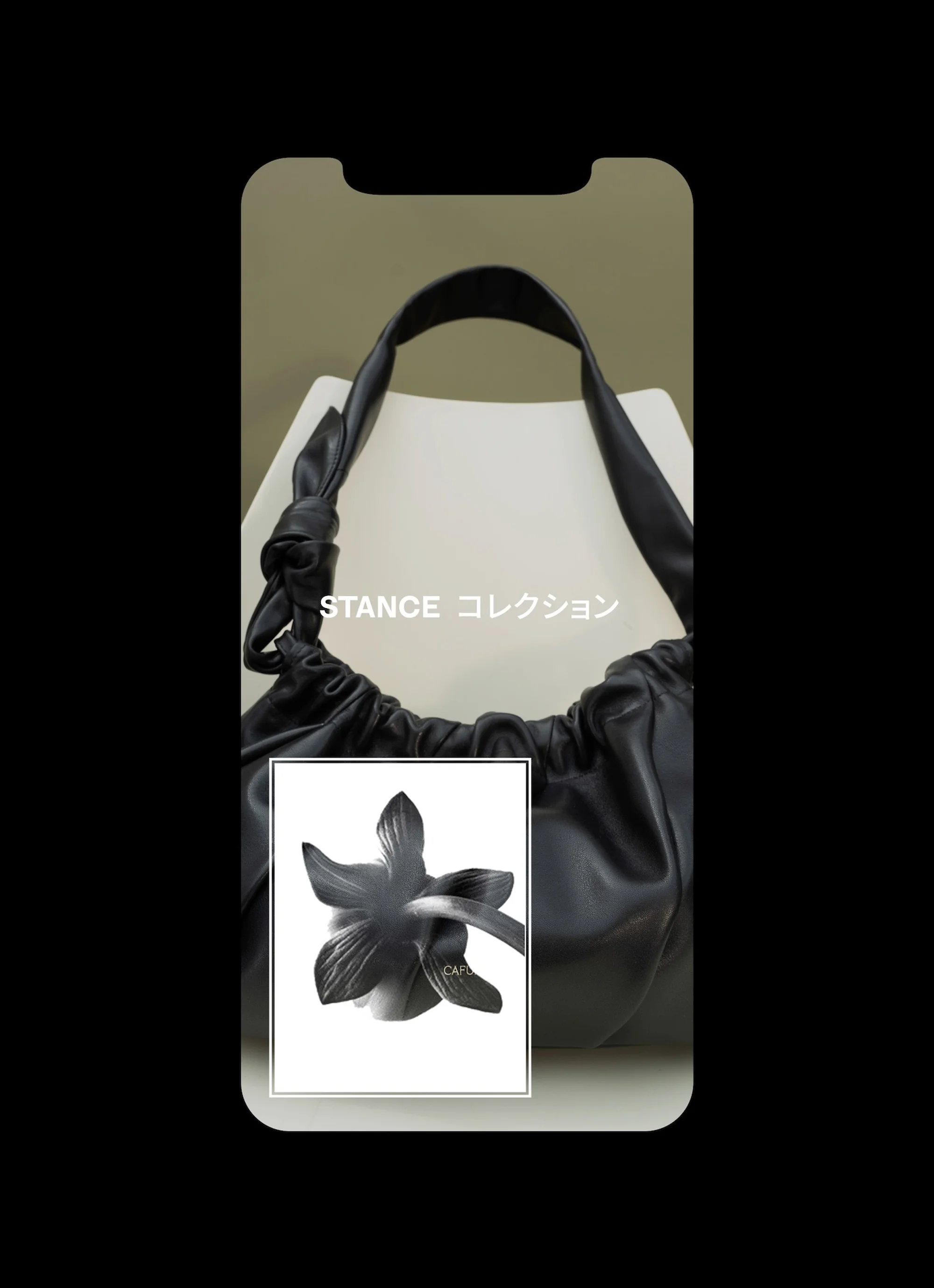 Black faux leather drawstring hobo bag with shoulder strap and flower graphic displayed on a phone screen mockup, studio shot.