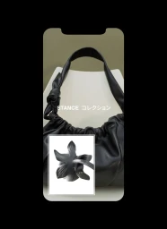 Black leather shoulder bag resting on a white chair with Japanese typography overlay and an inset botanical flower graphic