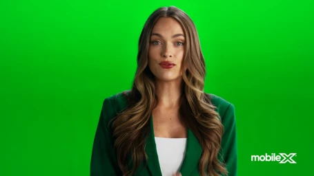 Woman with long brown hair wearing a green blazer against a green screen background for MobileX