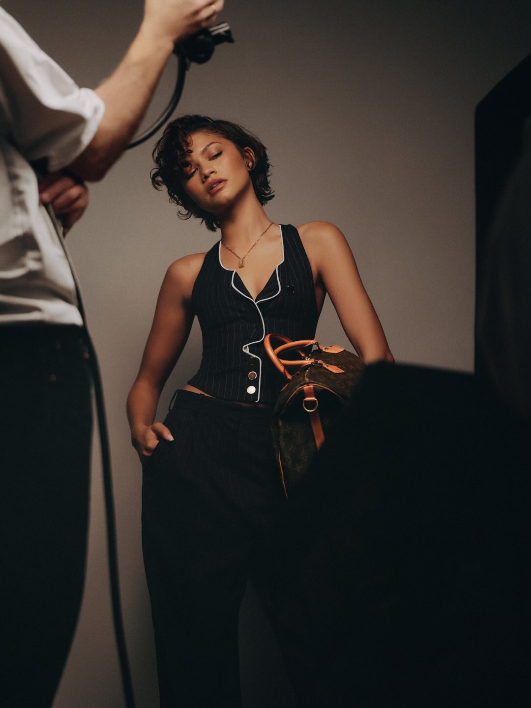 Zendaya posing indoors with a Louis Vuitton bag in a fashion editorial-style photograph taken in a photo studio setting.