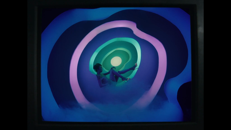Abstract composition of a person in heels lying inside a digitally generated circular tunnel with blue and purple gradient lighting.
