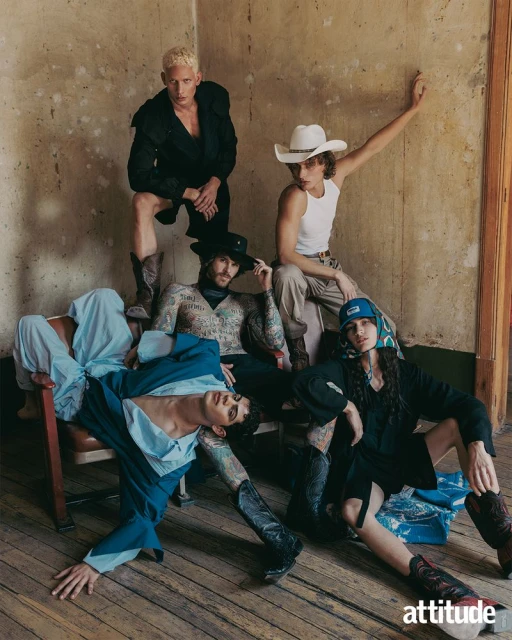 Group fashion shot of five men in an indoor setting, posing with boots and hats, captured in medium shot with natural lighting, style editorial.