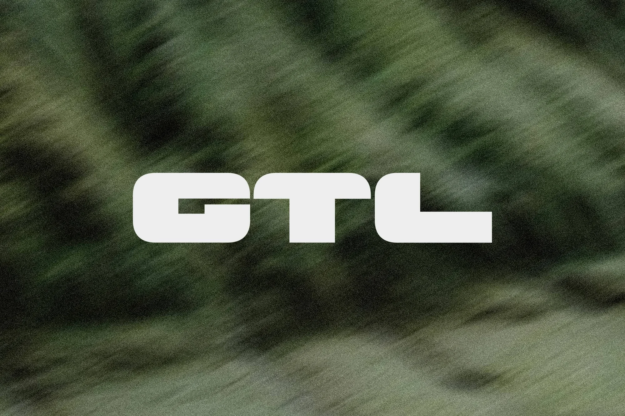 Abstract image with the bold white text "GTL" set against a green, blurred background, creating a dynamic and eye-catching composition.