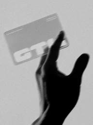 Monochrome motion-blurred image of a hand reaching toward a transparent card displaying the GTL brand identity.