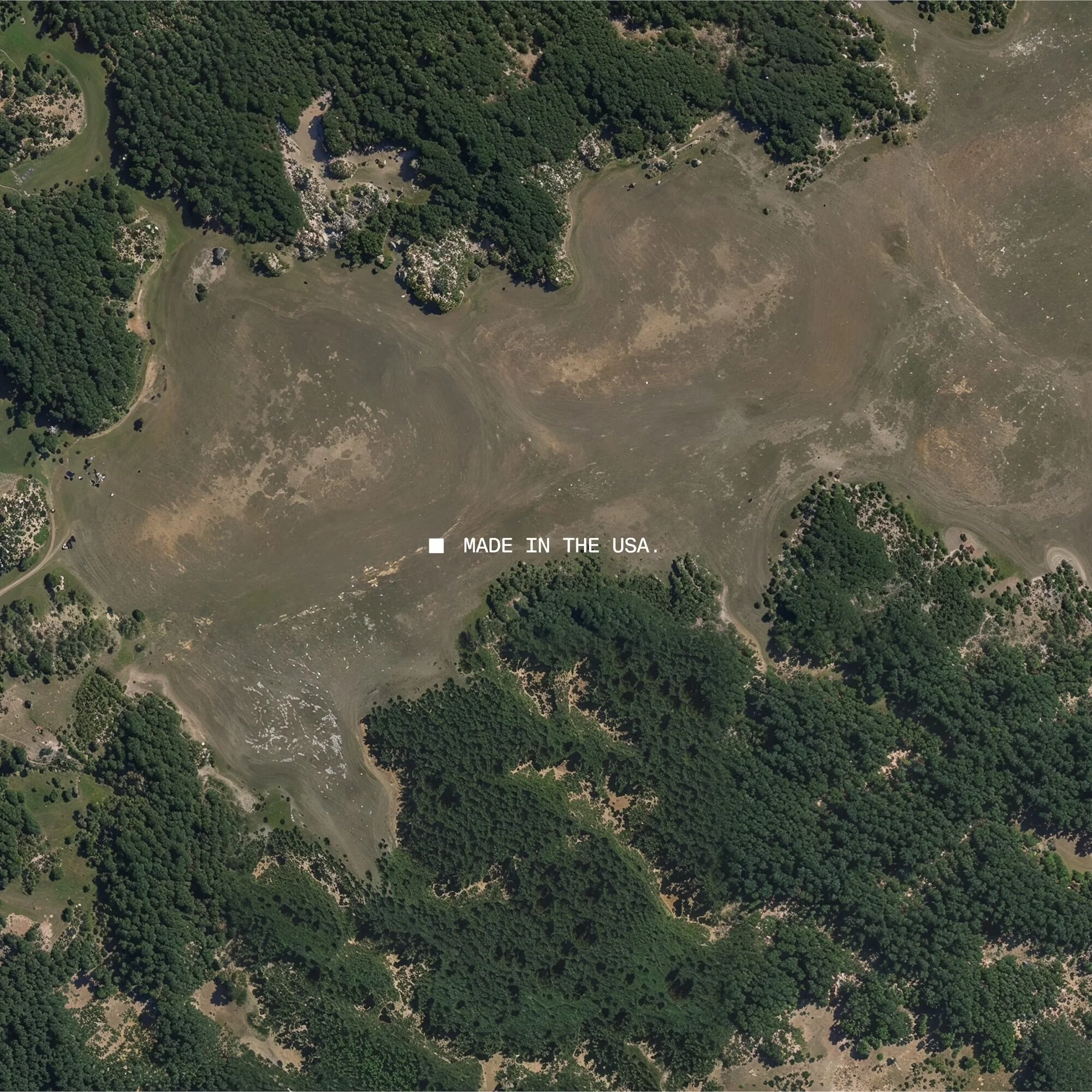 Aerial view of a rural landscape featuring trees and a barren area, with the text "MADE IN THE USA" overlaid on the image.