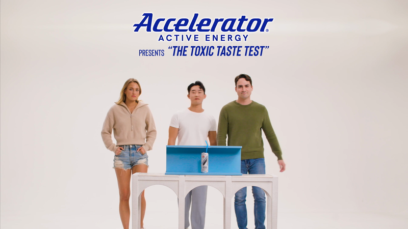 Three people stand behind a table with a beverage can in front of a white background with the Accelerator Active Energy logo above.