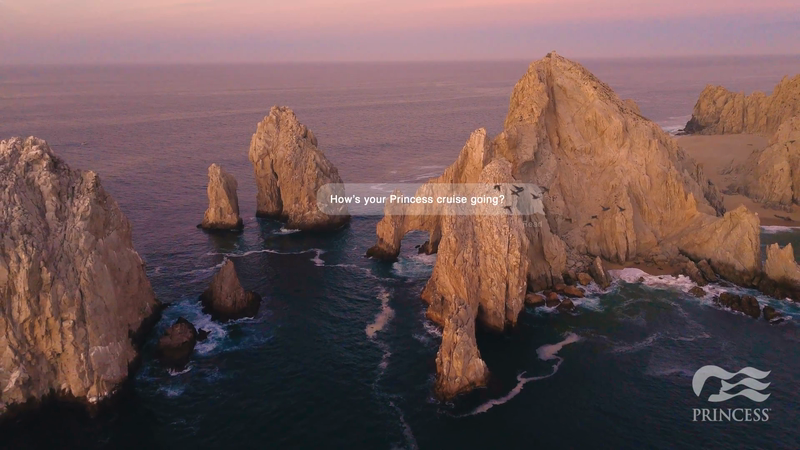 Coastal rock formations and blue ocean under a pastel pink and blue sky, featuring the Princess Cruises logo in the lower right corner.