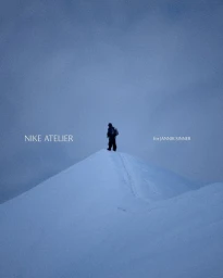 Athlete standing on a snow-covered mountain peak under a cool blue sky with text reading Nike Atelier and for Jannik Sinner.