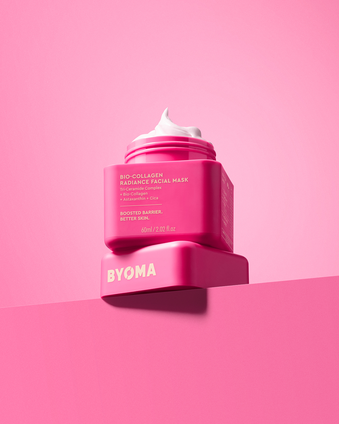 Close-up product shot of BYOMA Bio-Collagen Radiance Facial Mask in pink packaging with white cream against a pink background.