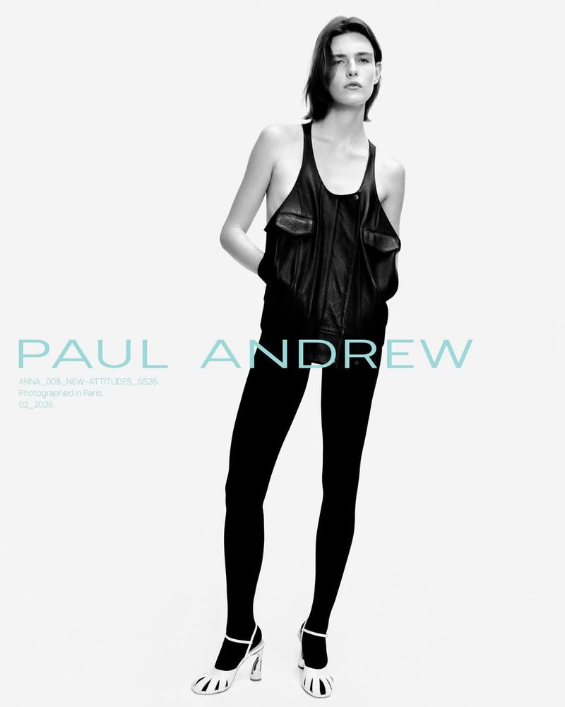 A fashion shot features a female model posing in a sleeveless black top, leggings, and white heels against a pale backdrop. The image is in black and white.