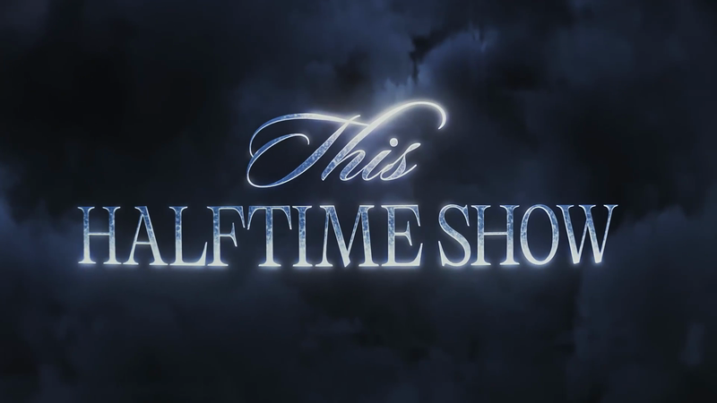Illuminated text graphic displaying 'This HALFTIME SHOW' against a cloudy, dark blue background creates a dramatic, theatrical visual.
