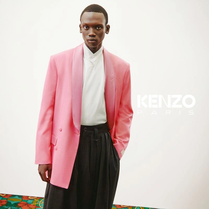 Model wearing a pink blazer and white shirt against a plain white background with Kenzo Paris branding