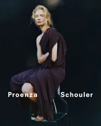 Model in dark dress seated on a stool against a dark background with Proenza Schouler branding