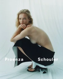 Model crouching against a white backdrop wearing a black skirt with white lining for Proenza Schouler