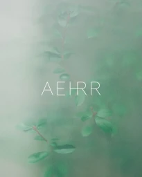 Green leaves viewed through frosted glass with the white typography text AEHRR centered in the frame