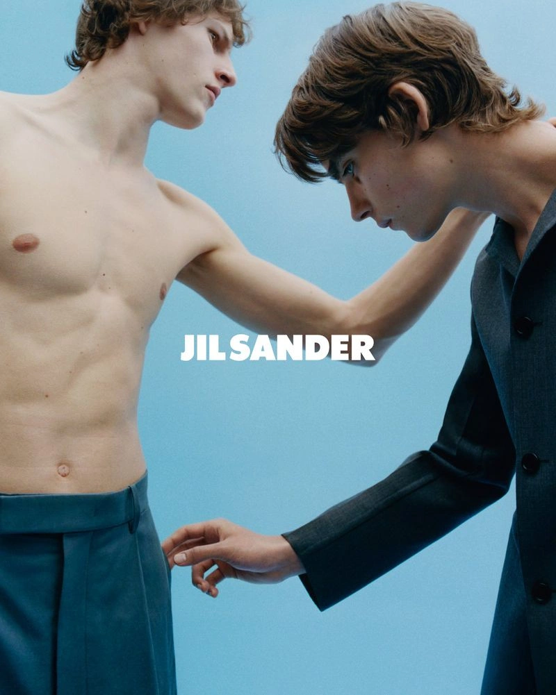 Two male models posing against a light blue backdrop for Jil Sander S/S 2026 campaign photographed by Stef Mitchell.