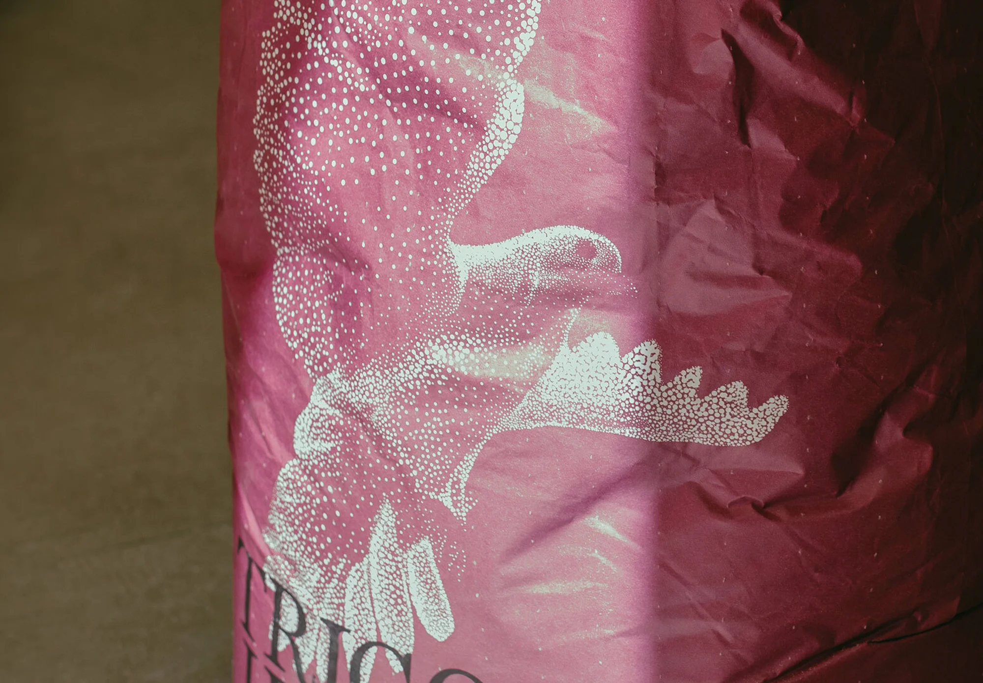 Abstract red and pink texture with white dotted pattern resembling a stylized flower or plant design, covering most of the frame.