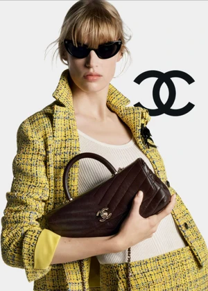 Model in yellow tweed jacket wearing dark sunglasses and holding a brown quilted handbag for Chanel Spring Summer 2026 Pre-Collection