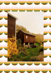 Wooden barn building surrounded by lush greenery and foliage framed by a decorative border pattern