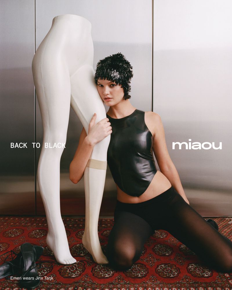 A woman poses in black attire next to a mannequin in a studio setting, showcasing fashion against a neutral background with text overlay.